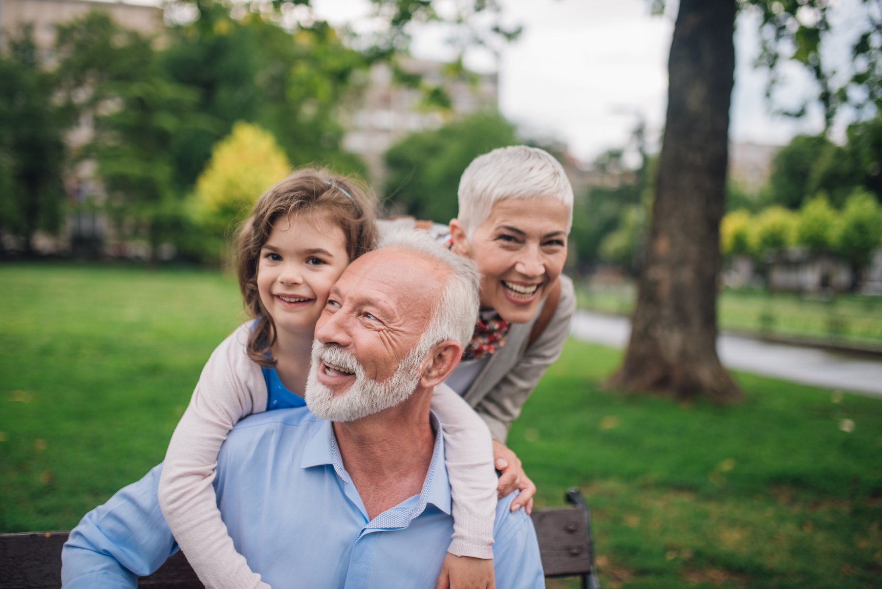 Happy family hugging elderly man